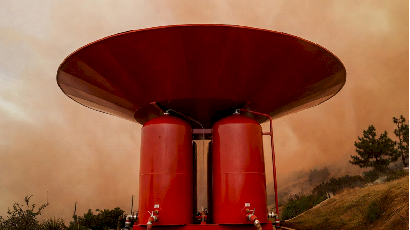 FIREWALL unit close-up against dramatic wildfire sky